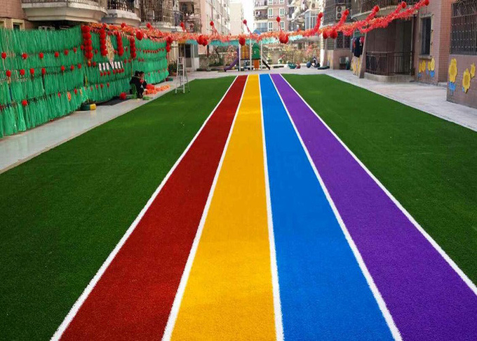 A pista de atletismo coloriu os tapetes artificiais da grama para ajardinar a decoração 0